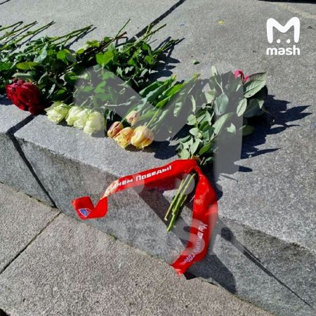 В Риге коммунальщики с трактором убирают цветы, оставленные у Монумента освободителям
